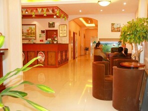 Eine Hotelhalle mit Empfangstresen, Sitzgelegenheiten und einem Aquarium.