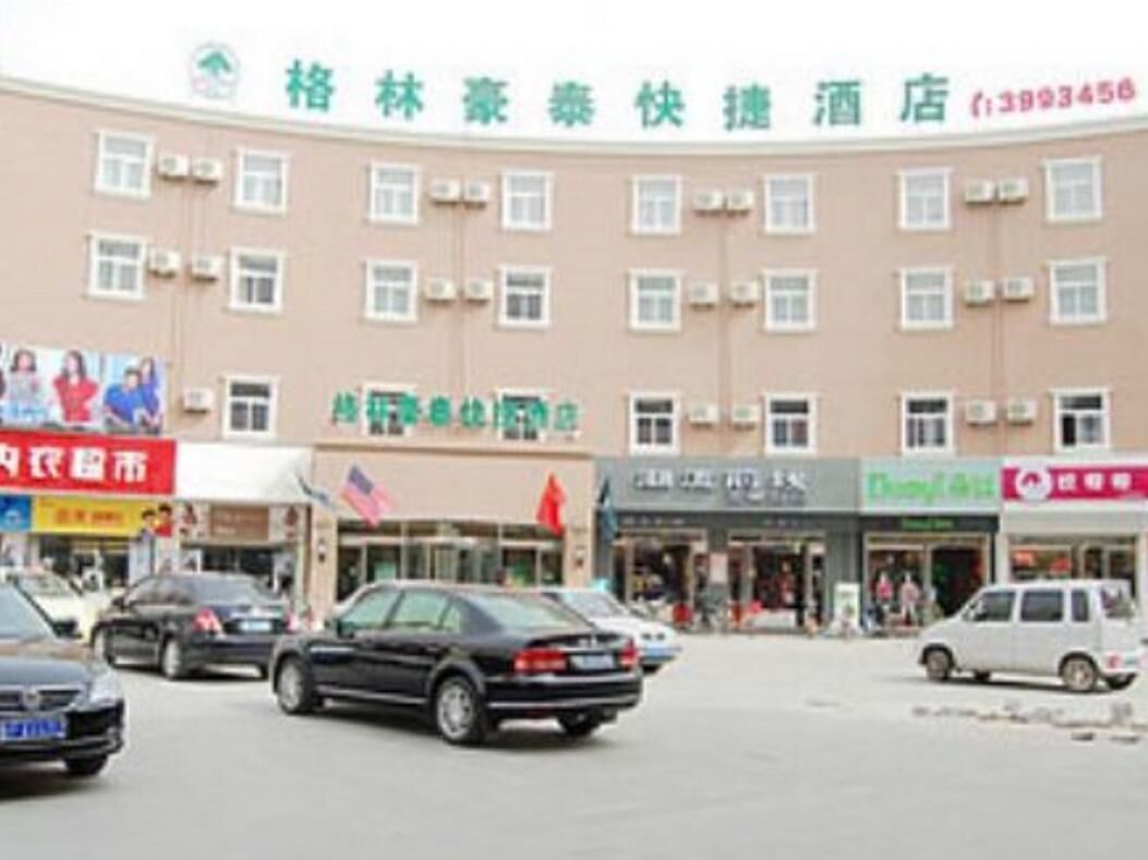 Un hotel de varios pisos, con unidades de aire acondicionado en el exterior y varias tiendas en la parte delantera.