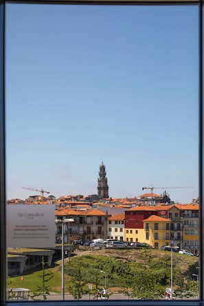 A view of a cityscape with a prominent tower, colorful buildings, and construction cranes. - Se Catedral Hotel Porto, Tapestry Collection by Hi (Porto)