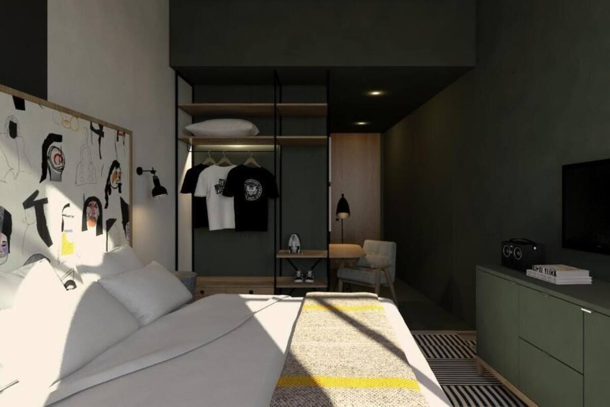 A modern bedroom with a bed, a desk with a chair, a TV, and a wardrobe.