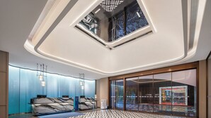 Eine moderne Hotelhalle mit einer Marmorrezeption, einem gemusterten Boden und einem Oberlicht.