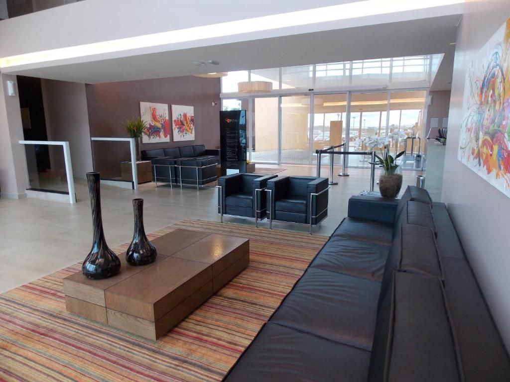 A modern lobby with seating areas, a reception desk, and artwork on the walls.