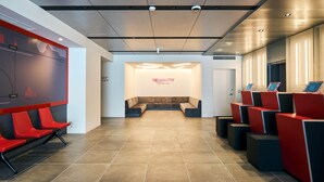 A reception area with a modern design, including a seating area with sofas and a counter with a digital display. - Rakuten STAY Osaka Station North (Osaka)
