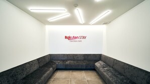 A waiting area with a dark, textured bench and a tiled floor. - Rakuten STAY Osaka Station North (Osaka)