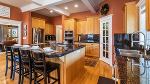 A modern kitchen with wooden cabinets, stainless steel appliances, and a granite countertop. - Royal Oak Manor Lrg private home and yard sleeps 18! (Bend)
