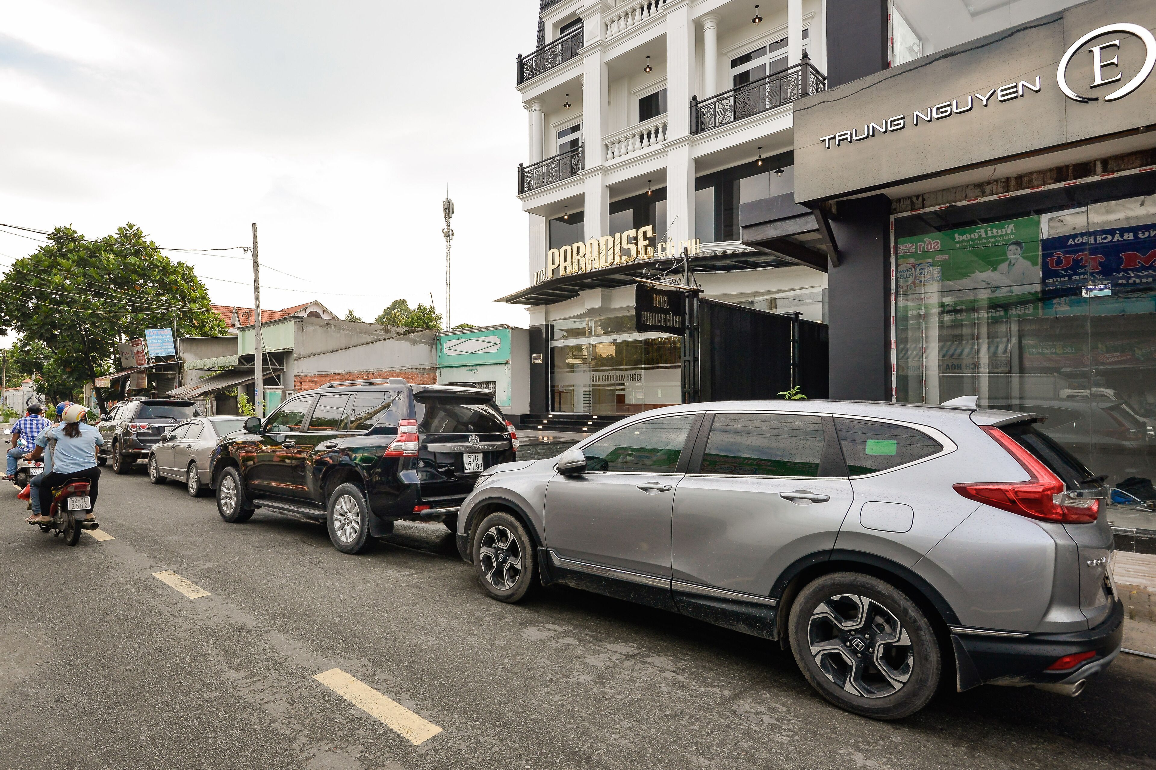 Una calle con autos estacionados y un edificio con un letrero que dice "Paradise".