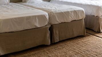 Una habitación de hotel con dos camas, un cuadro en la pared y una lámpara en el techo.