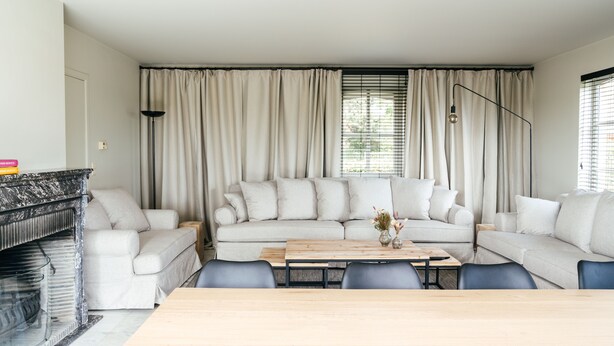 Ein Wohnzimmer mit einer Sofagarnitur, einem Couchtisch und einem Kamin.