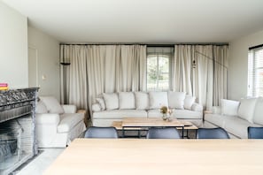 A living room with a sofa set, a coffee table, and a fireplace.