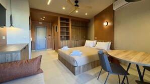 Una moderna camera d'albergo con un letto, una scrivania e un'area ristoro.