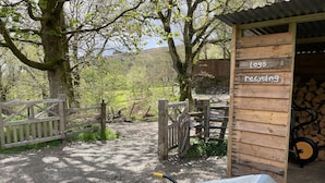 A gravel path leading to a wooden structure labeled "Logs recycling." - Cosy Woodland off Grid Shepherds Hut - Rowan (Castle Douglas)