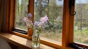A window with a view of trees and a wooden window frame. - Cosy Woodland off Grid Shepherds Hut - Rowan (Castle Douglas)