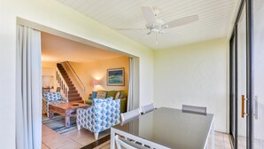 A dining area with a table and chairs, a ceiling fan, and a view of a staircase leading to another room. - SOUTH Villa 5310 - Three bedroom condo with Bay views (Captiva)
