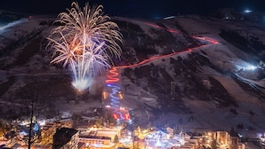 Eine Stadt mit Bergblick, beleuchteten Gebäuden und einem Feuerwerk.