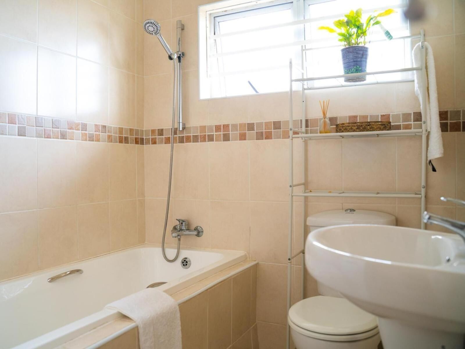 Un baño con bañera, ducha, inodoro y lavamanos.