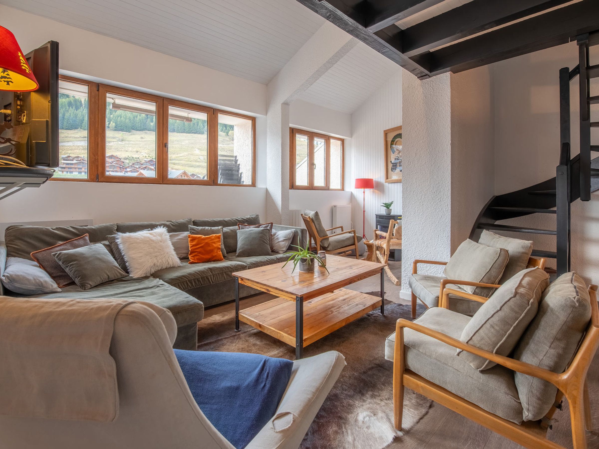A spacious living area with a sofa, chairs, a coffee table, and a fireplace.
