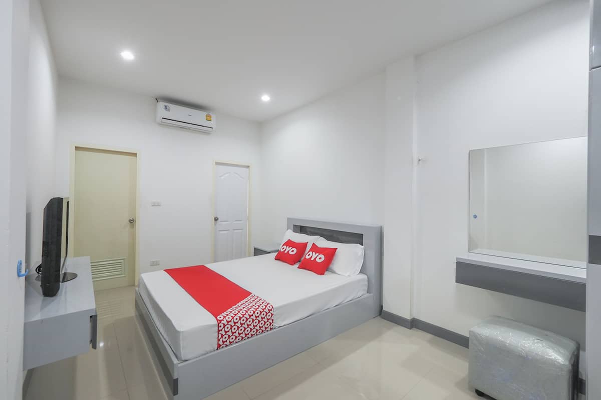 Une chambre d’hôtel avec un lit, un bureau, un climatiseur, une porte et une fenêtre.