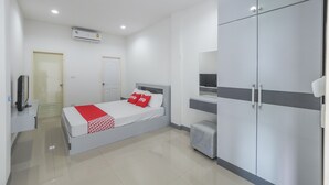 A modern hotel room with a bed, wardrobe, and a television. - K&k Apartment (Bang Phli)