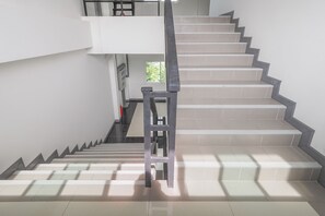 Una escalera con barandilla que lleva a un piso superior.
