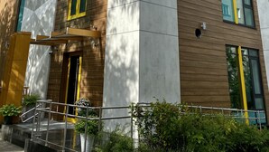 A modern hotel building with a prominent 'HOTEL' sign, large windows, and a mix of wood and concrete materials. - Botanica Hotel (Arkhangelsk)