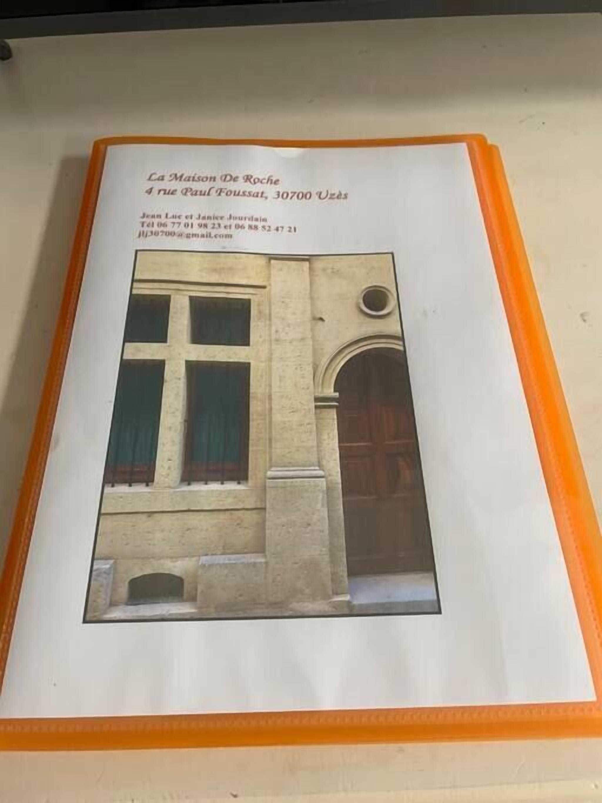 Een lijst met een foto van een gebouw met een groot raam en een rondboogdeur, omgeven door een beige muur.