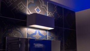A modern interior with geometric wall patterns and a central light fixture. - Frattina FF (Rome)