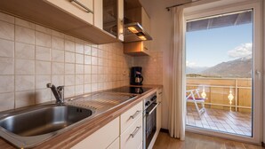 A kitchen with a stainless steel sink, wooden countertop, and an oven. - Apartment "Residenz Kronstein - 5" with Balcony, Garden, Mountain View & Wi-Fi (Tisens Italien)