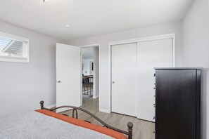 Un dormitorio con cama, armario y puerta que da a otra habitación.