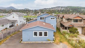Zona residencial con casas, cielo despejado y colinas al fondo.