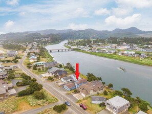 A residential area with houses along a river, a bridge, and a road. - #155 Nestucca Sunrise · Riverfront, Close to Ocean Beaches, Large Yard (Pacific CIty)