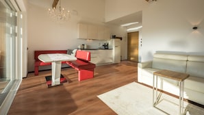 A modern living room with a red sofa, a white table, and a wooden coffee table. - Apartment "Berg und Tal - Schlosserhaus 31" with Balcony and Mountain View (Tisens Südtirol)