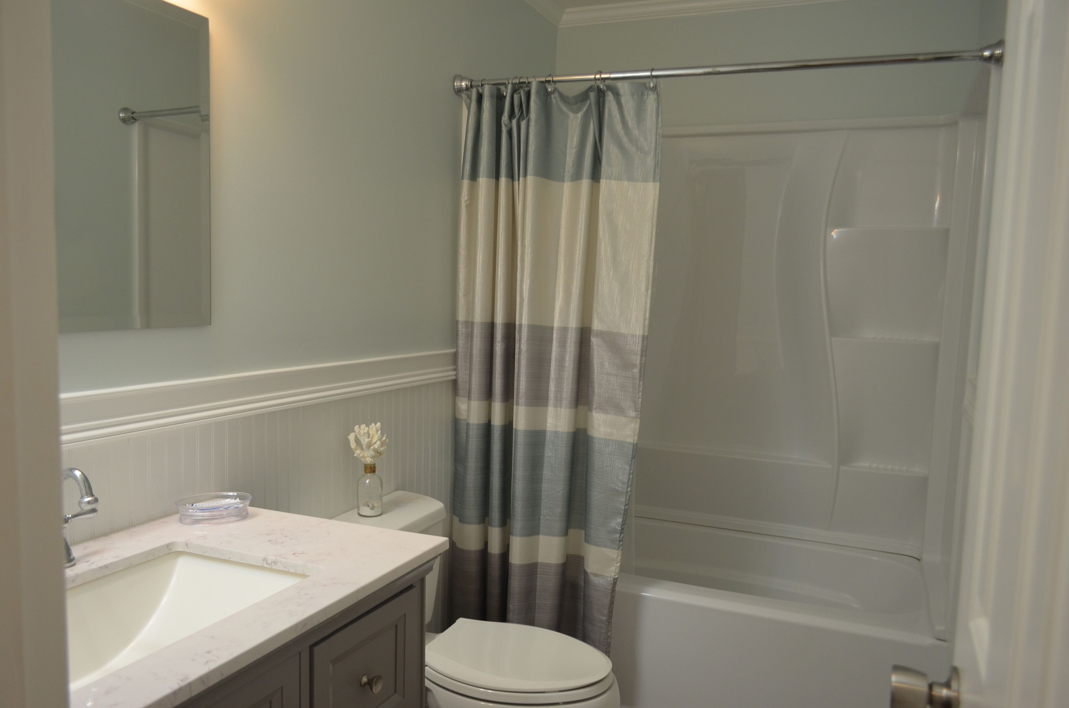 Une salle de bain avec un lavabo, des toilettes et une baignoire, le tout de couleur blanche.