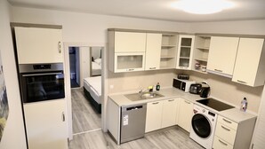 Eine kompakte Küche mit Geschirrspüler, Mikrowelle, Backofen und Waschmaschine.