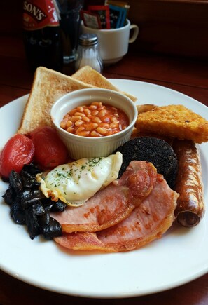 A plate of breakfast food including toast, beans, sausages, eggs, tomatoes, and black pudding. - Park Hotel & Apartments (Hull)