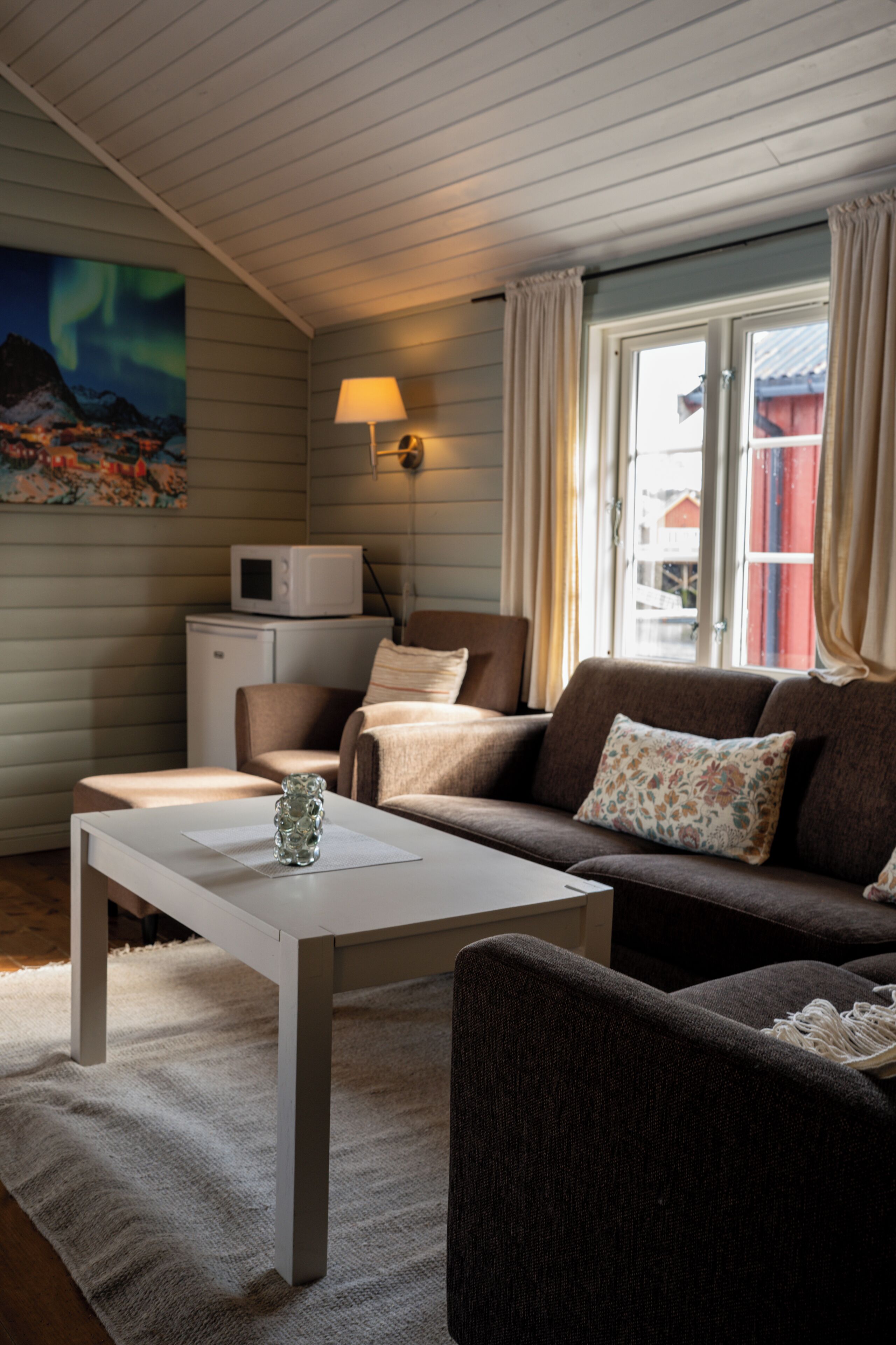 A cozy living room with a sofa, a coffee table, a lamp, and a TV.