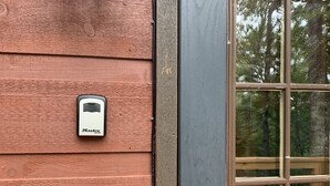 Una puerta de madera con una ventana, un timbre y una etiqueta del sistema de seguridad.