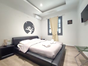 A modern bedroom with a large bed, a wall-mounted air conditioner, a window with curtains, and a motivational quote on the wall. - CASA DE MIKEL 2 RHODES TOWN (Rodos)