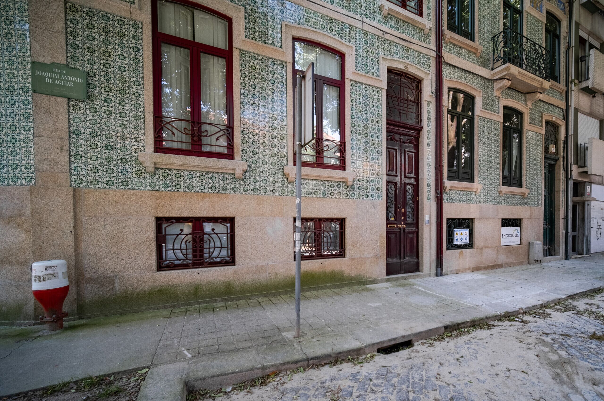 A building with patterned facade, multiple windows, and a sign indicating a business.