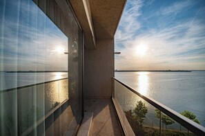 A balcony with a view of a body of water and a sunset. - Solid Magic Apart-Hotel (Constanta)