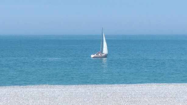 Un velero en aguas azules y tranquilas.