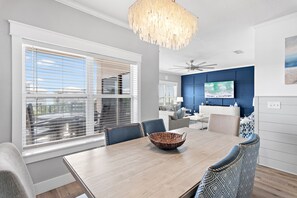 Un comedor con una mesa de madera, sillas, un cuenco decorativo y un ventilador de techo.