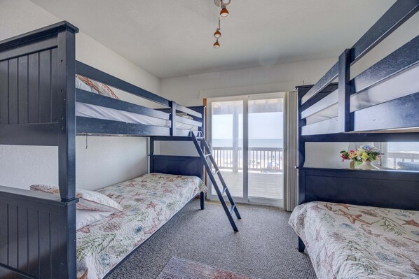 A room with bunk beds, a window with a view, and a ladder. - 7048- Tide Song - Dog-Friendly Oceanfront Rodanthe Retreat (Rodanthe)