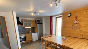 A compact living space with a dining area, kitchenette, and a cozy seating area.