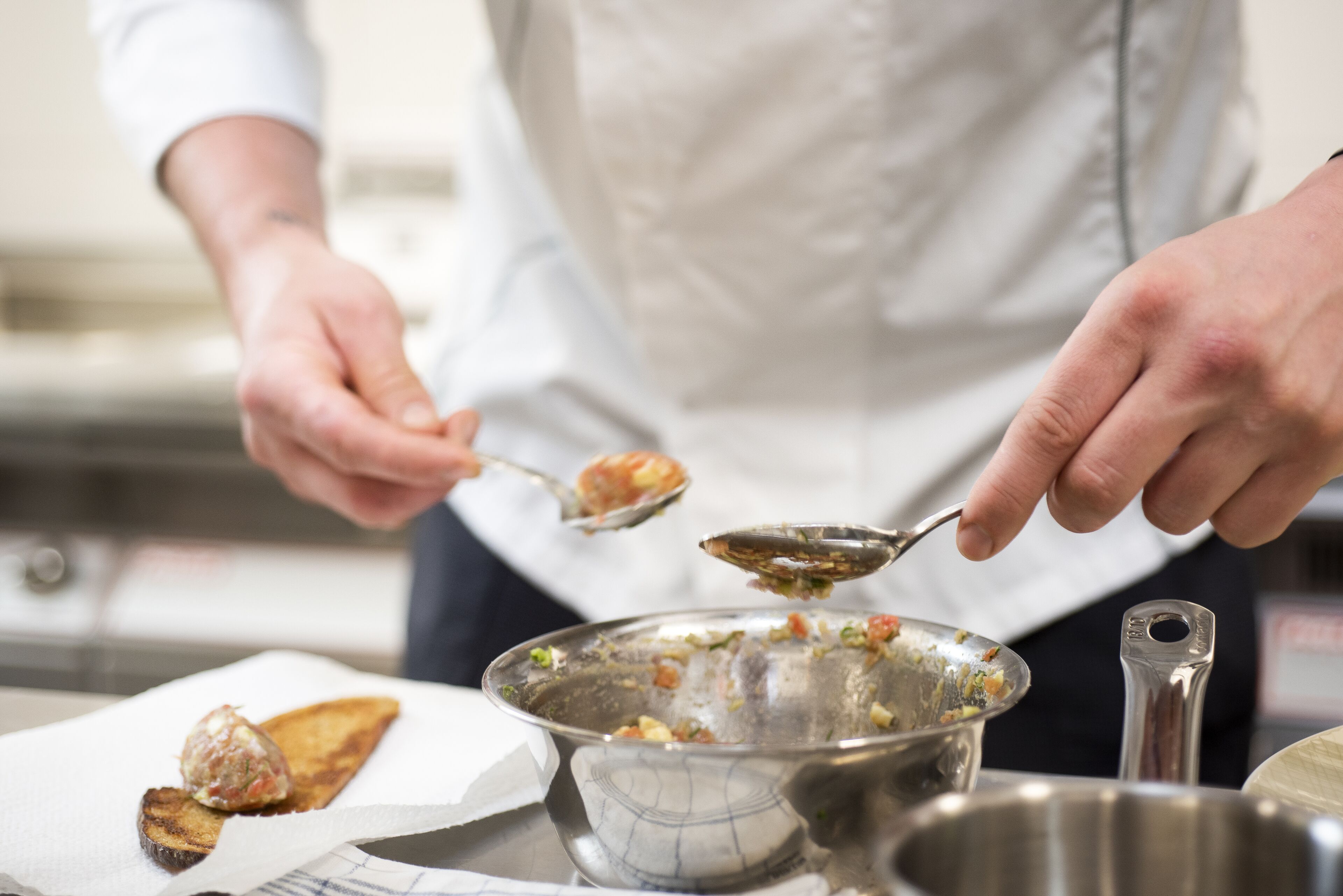 A person serving food from a metal bowl.