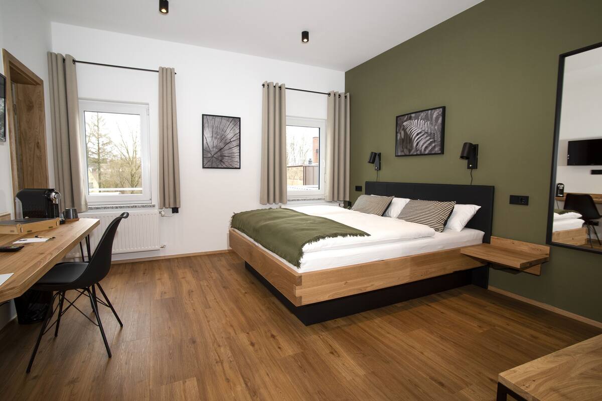 Une chambre à coucher moderne avec un lit en bois, un bureau et une chaise.