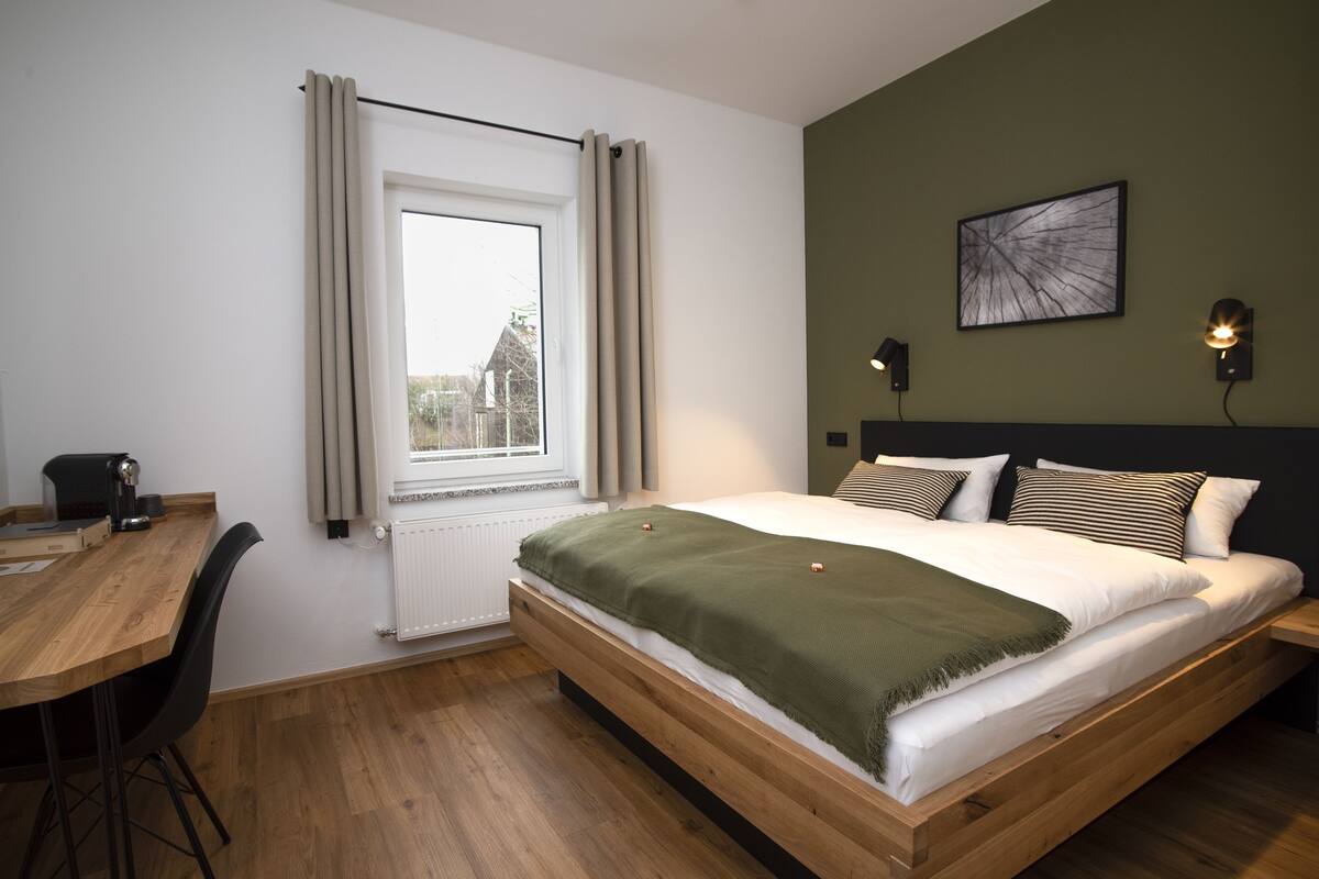 Une chambre à coucher avec un lit en bois, un bureau et une chaise.