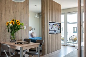 Suite estudio panorámica | Área de sala de estar | Televisión LCD de 40 pulgadas con canales por cable y televisión