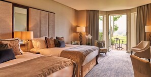 A hotel room with two beds, a sitting area with a chair, a table, and a view of the outdoors. - Rockliffe (Darlington)