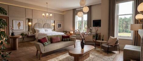 A spacious bedroom with a large bed, a sofa, a coffee table, and a TV.