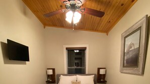 A bedroom with a bed, a ceiling fan, a window with blinds, a painting on the wall, and a bedside table with a lamp. - Cottage by the creek, beautiful Mountain View, perfect getaway!!! (Estillfork)